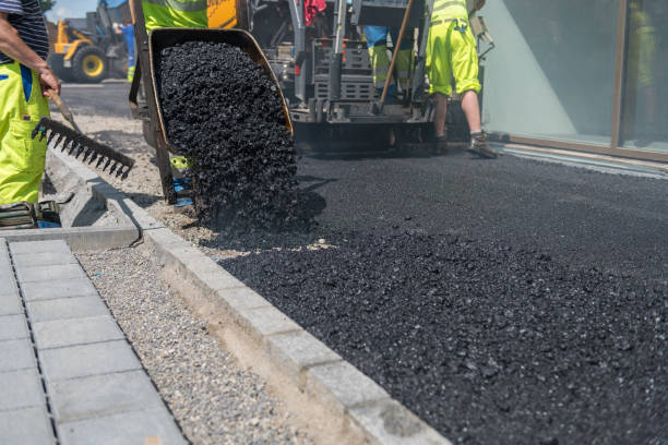 Street workers are working on a new street. Asphalt paver in the background.